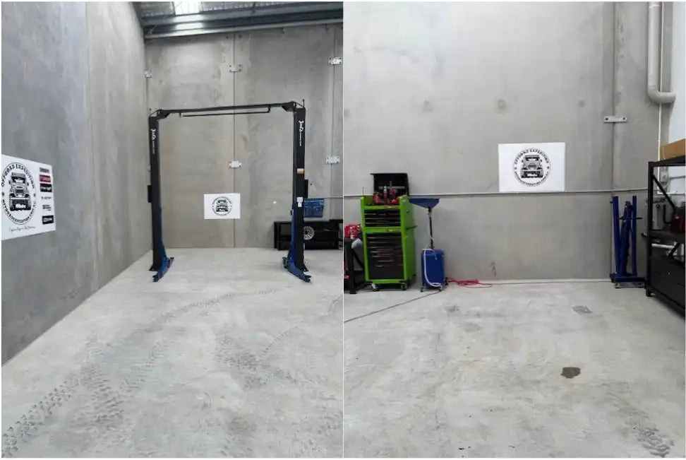 An empty car repair shop with a vehicle lift and tools.